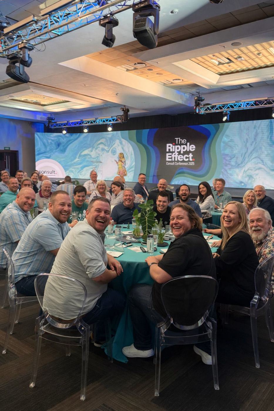 Delegates smiling around a table at a corporate conference
