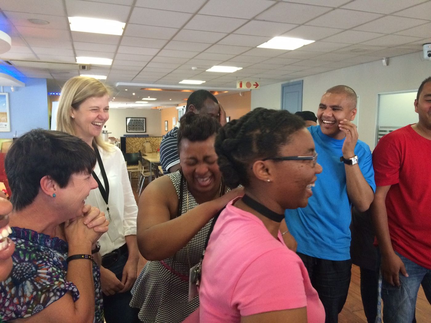 Delegates doubled over laughing together during a corporate session