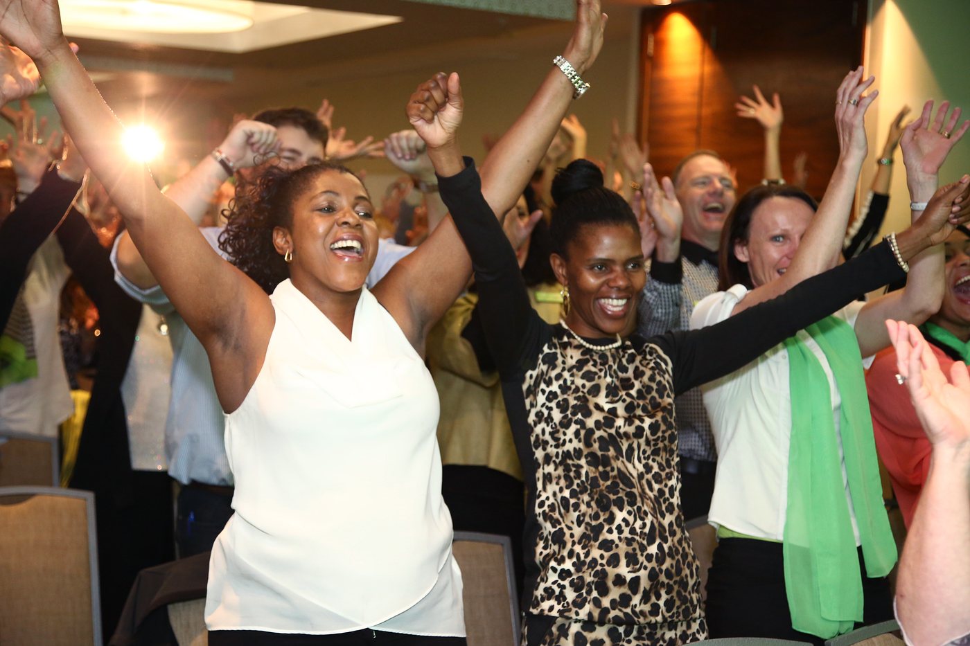 A corporate group laughing together in a laughter yoga and laughter coaching session
